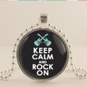 Keep calm and rock on. Guitar necklace, keep calm black and blue pendant, rock music, 1 inch silver Metal bezel pendant & glass dome. Metal, glass and Ball chain necklace.